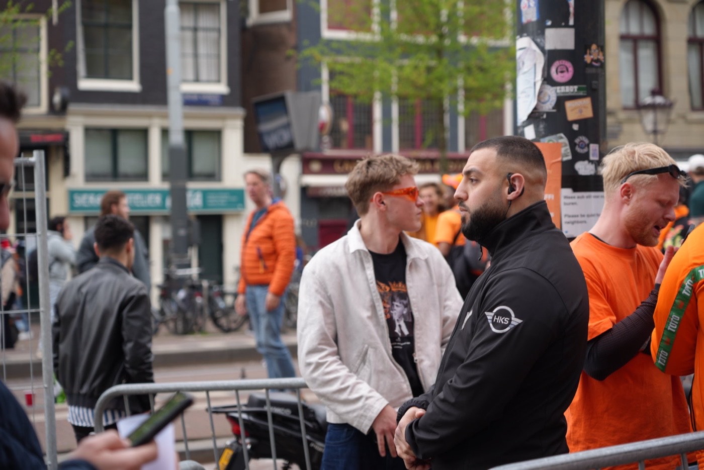 HKS-beveiligers in gesprek met bezoekers bij de dranghekken op Koningsdag